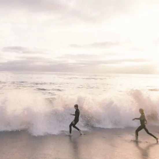 Swimmers running into the surf on Al Jurf's private beach